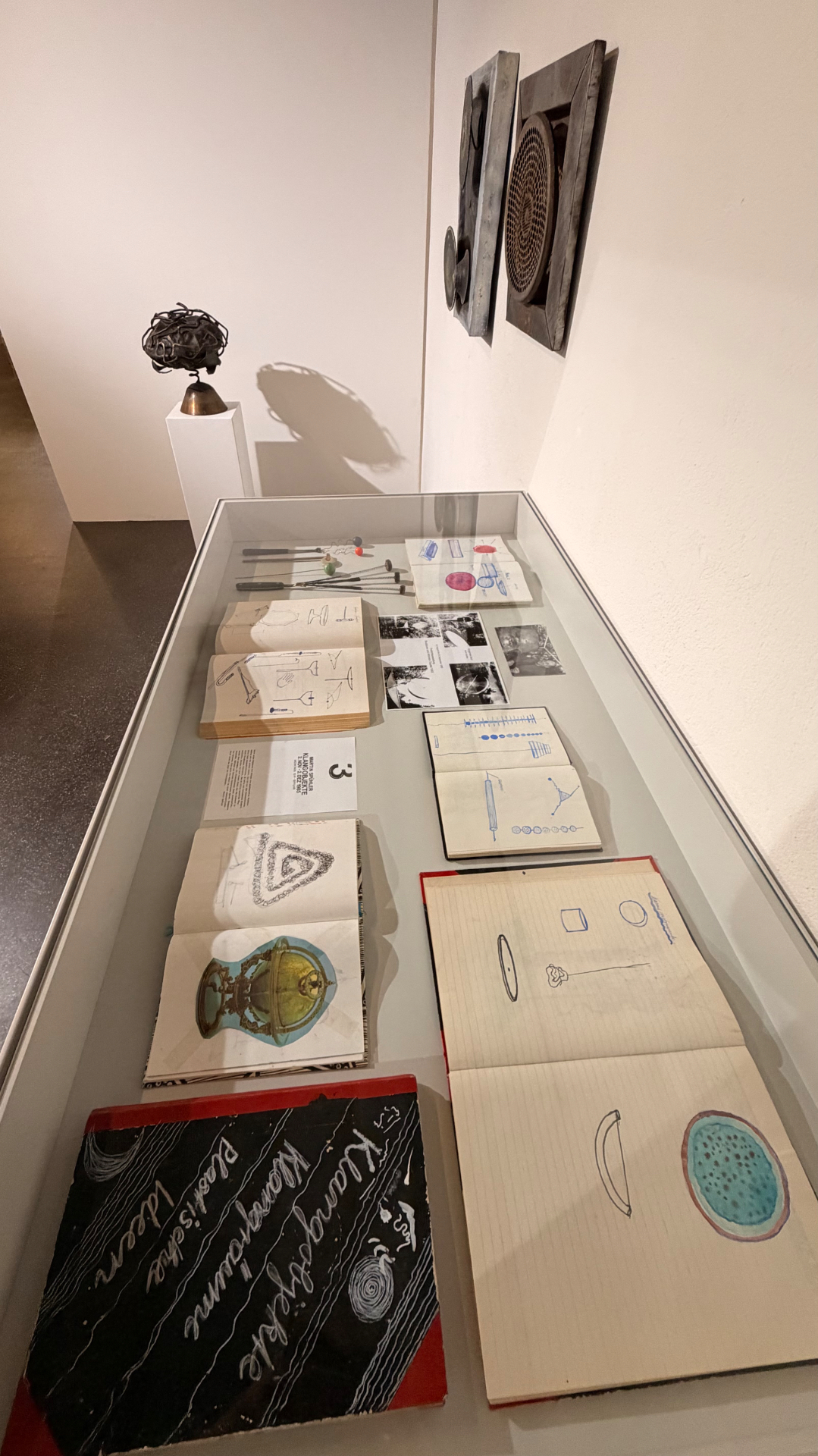 Exhibition view, vernissage — Display case with sketchbooks and sound tools, oxyd Winterthur